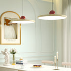 Lunara modern pendant light, two beige discs above a white table with a cherub statue