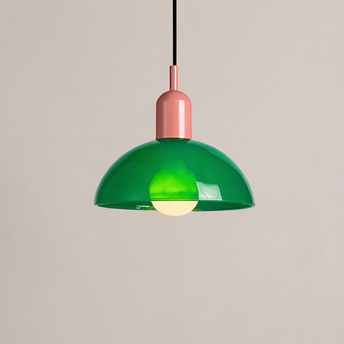 Aurora glass bowl pendant light, green shade with pink cap, studio shot on a neutral backdrop