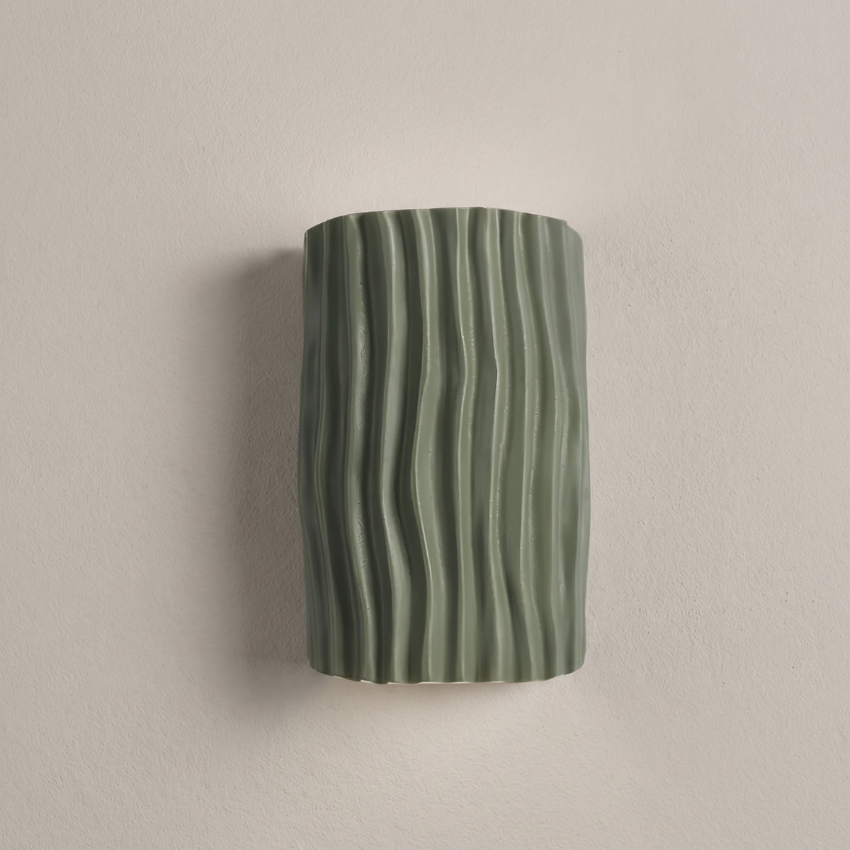 Clarity Curve wall sconce in green, wavy pleated front, studio shot on a neutral backdrop