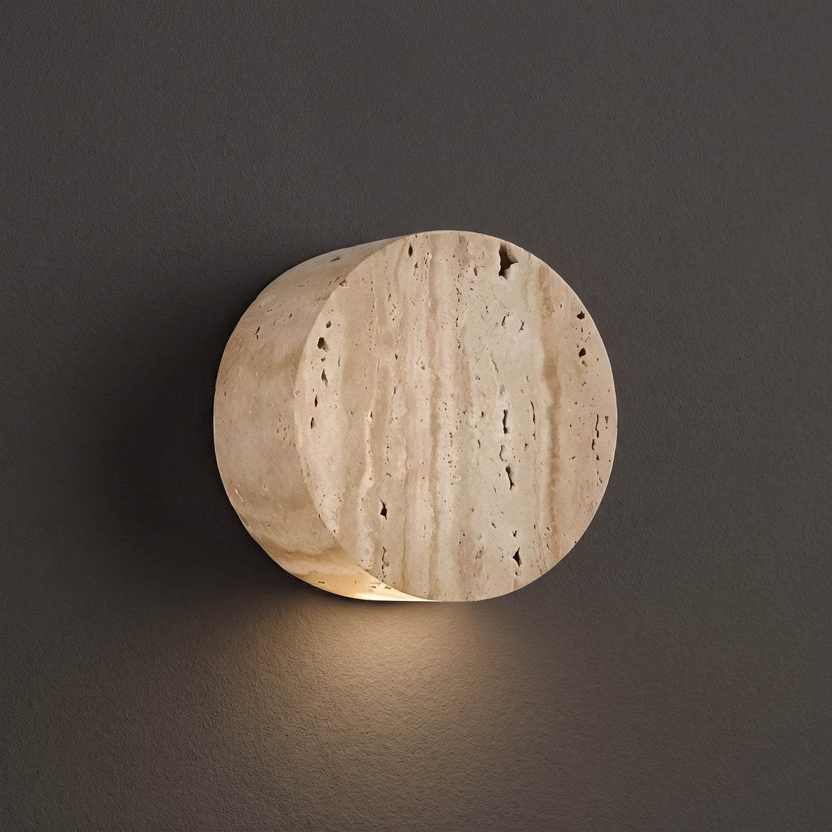 Wabi Sabi travertine and glass wall sconce, round stone drum, studio shot on a neutral backdrop