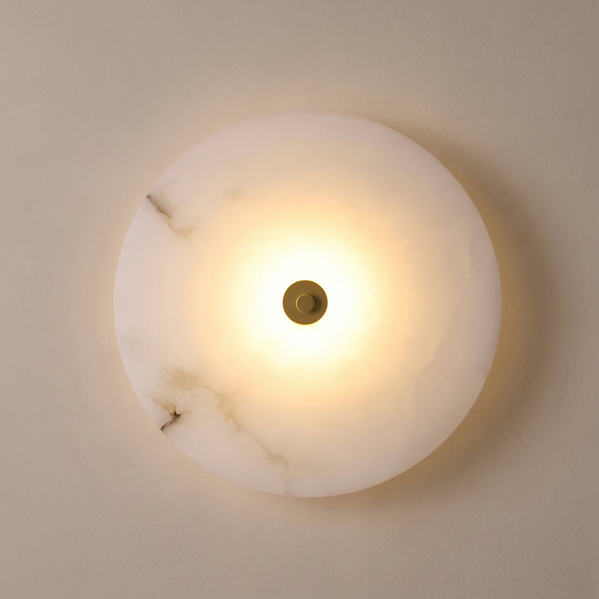 Round alabaster wall sconce, gold centre cap, studio shot on a neutral backdrop