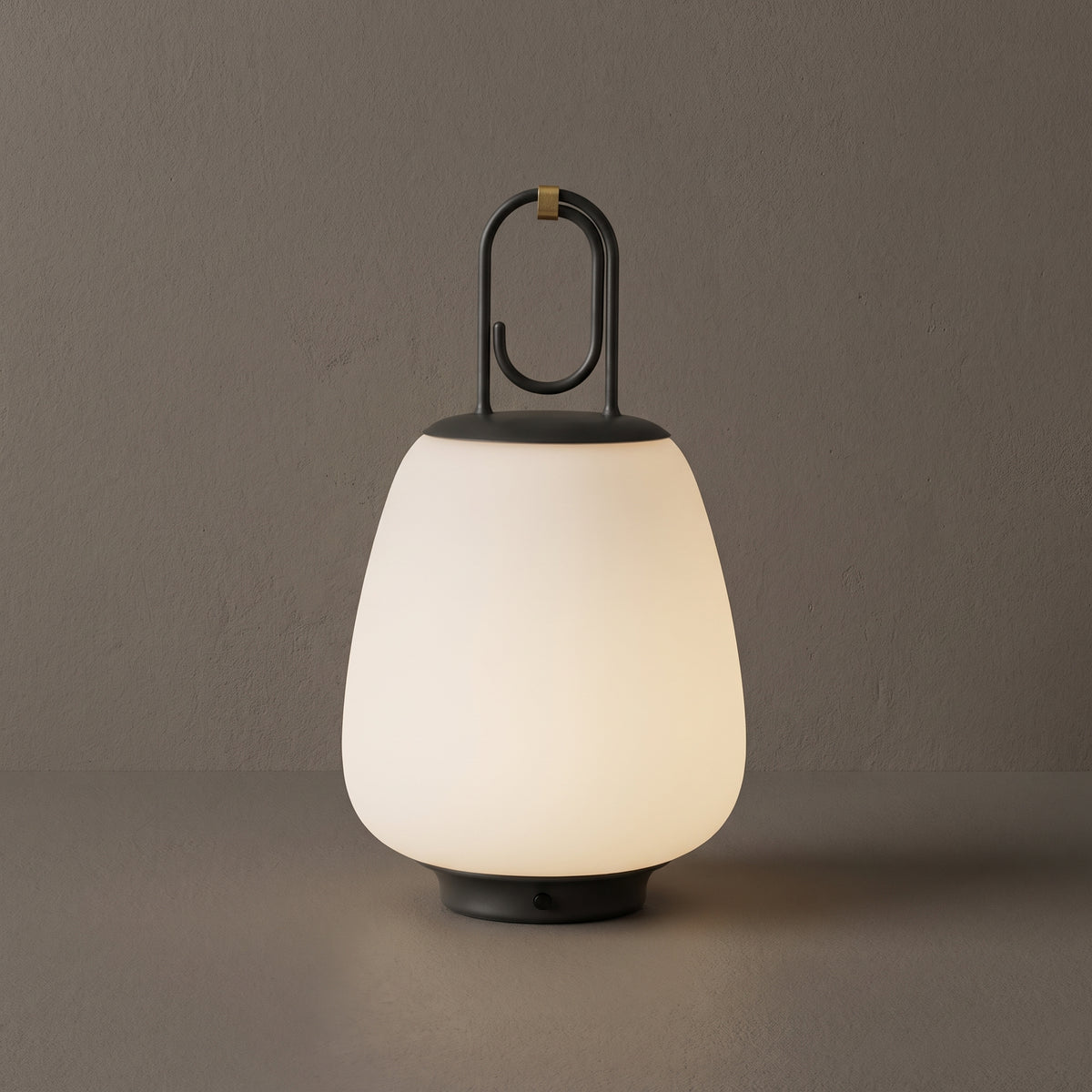NordGlow glass lantern table lamp, opal shade with black hook handle, studio shot on a neutral backdrop
