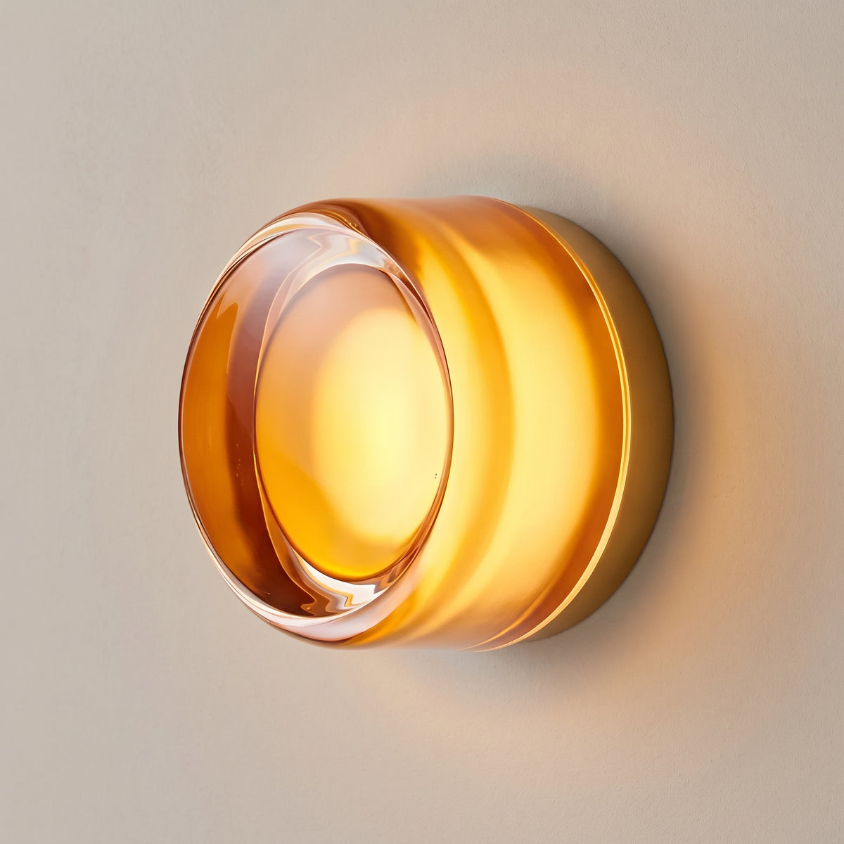 Dusk-to-dawn glass wall sconce, gold amber dimple lens, studio shot on a neutral backdrop