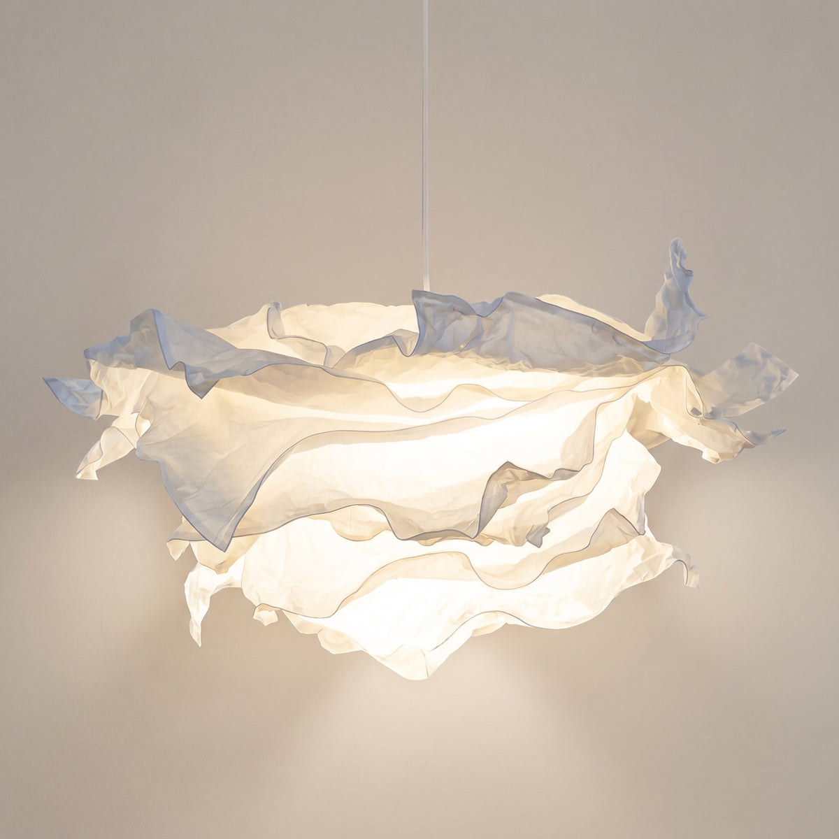 Japandi parchment cloud pendant light, crumpled white shade lit, studio shot on a neutral backdrop