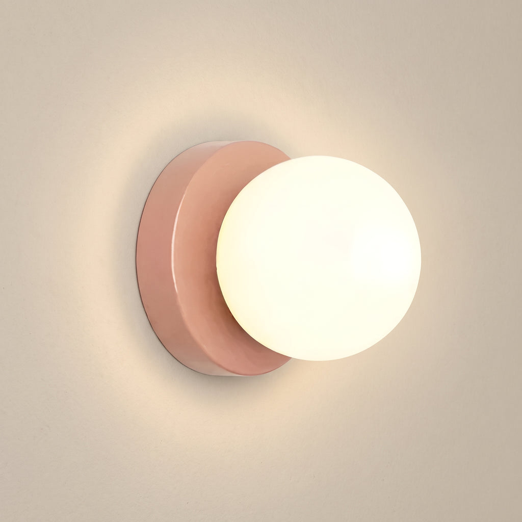 Minimalist opal glass globe wall sconce, pink base, studio shot on a neutral backdrop