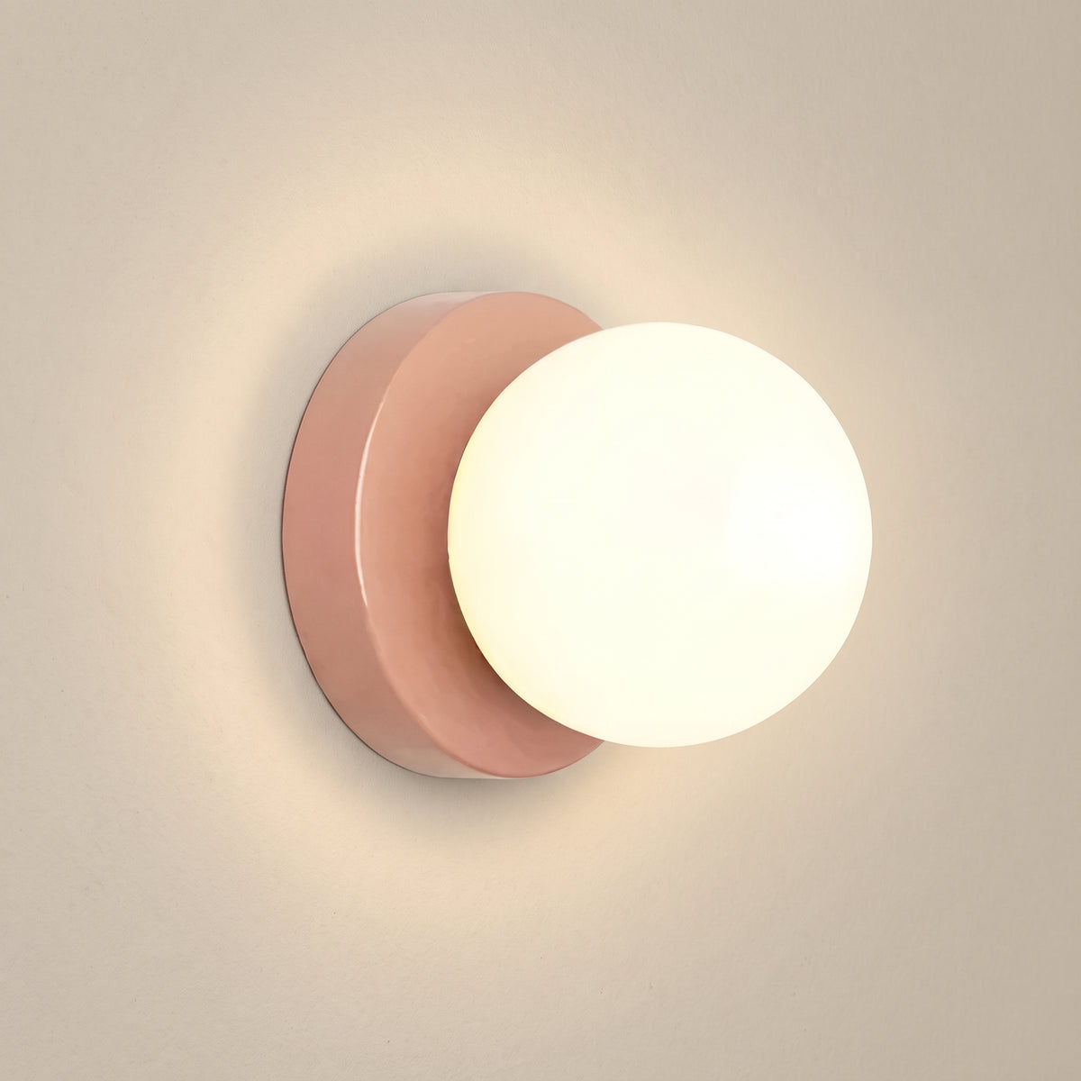 Minimalist opal glass globe wall sconce, pink base, studio shot on a neutral backdrop