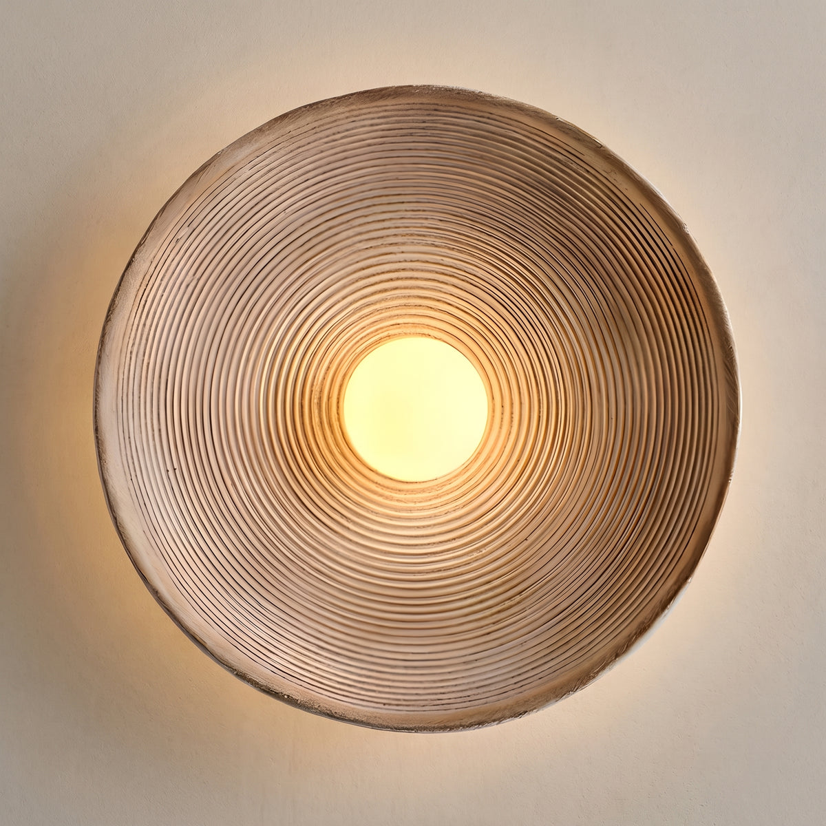 Japandi ribbed round wall sconce, weathered brown dish lit, studio shot on a neutral backdrop