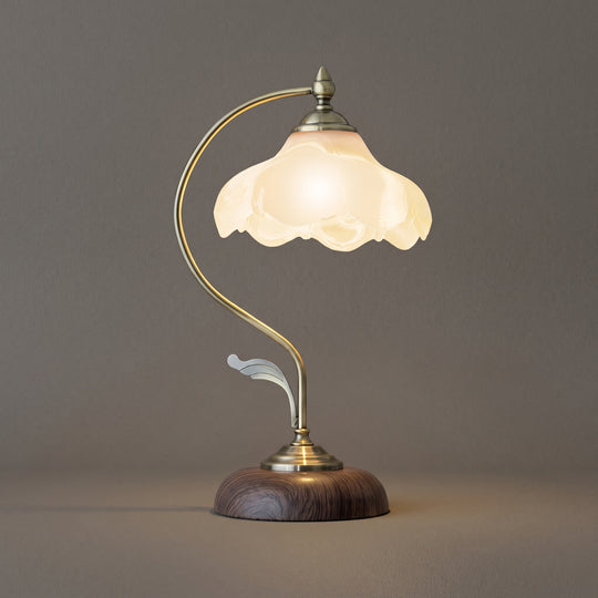 Midnight Mystery glass table lamp, brass gooseneck with scalloped shade and dark wood base, studio shot on a neutral backdrop