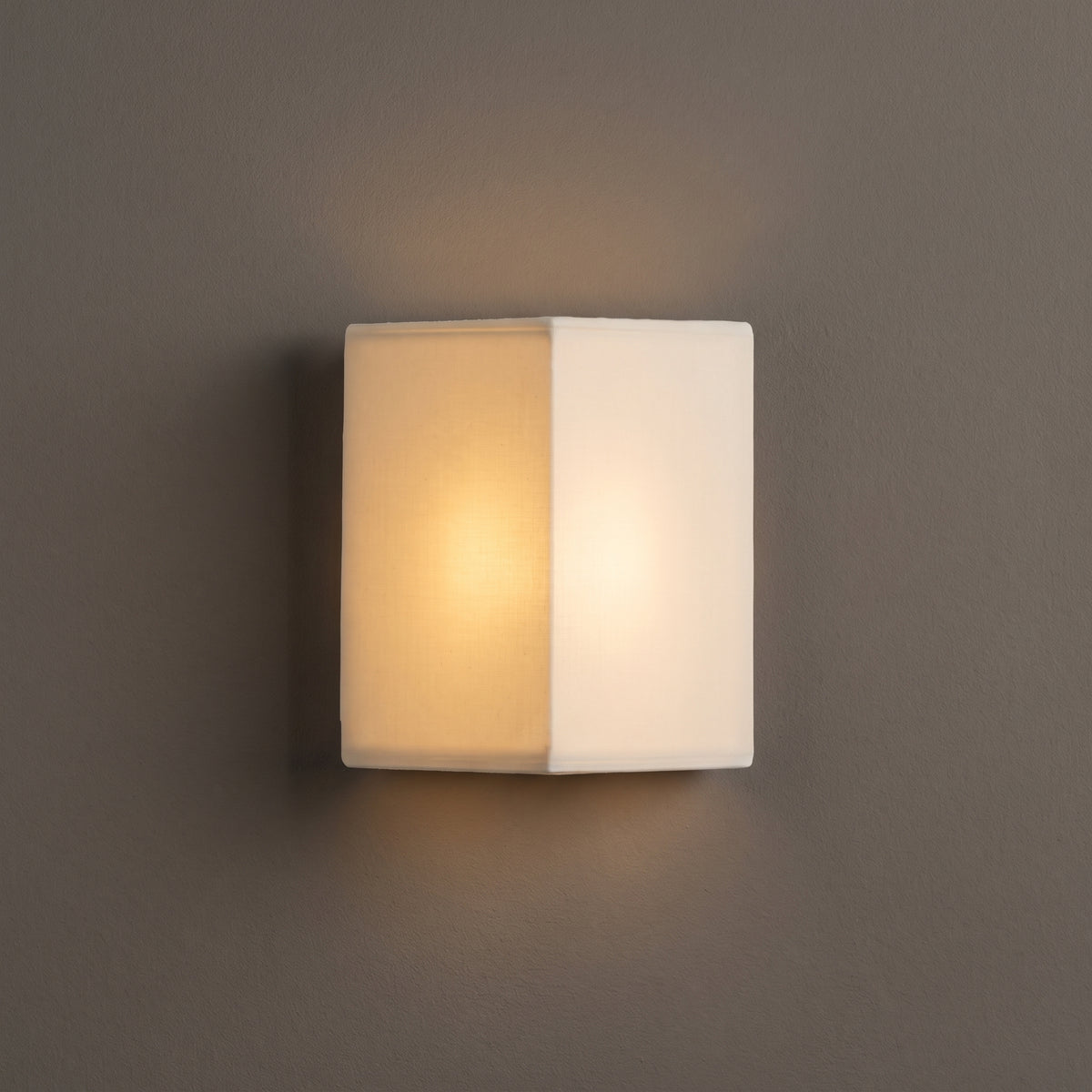 Zenform Glow fabric wall sconce, white triangular shade, studio shot on a neutral backdrop