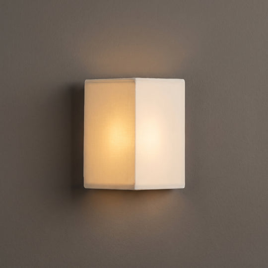 Zenform Glow fabric wall sconce, white triangular shade, studio shot on a neutral backdrop